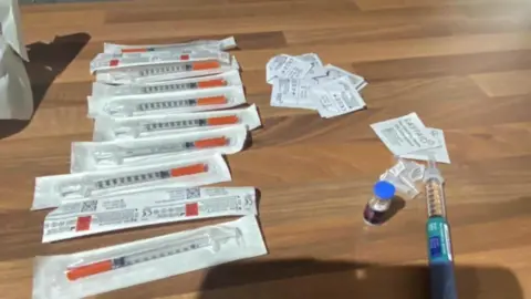 The fake pens bought by Michelle Sword. They are placed on a wooden table.